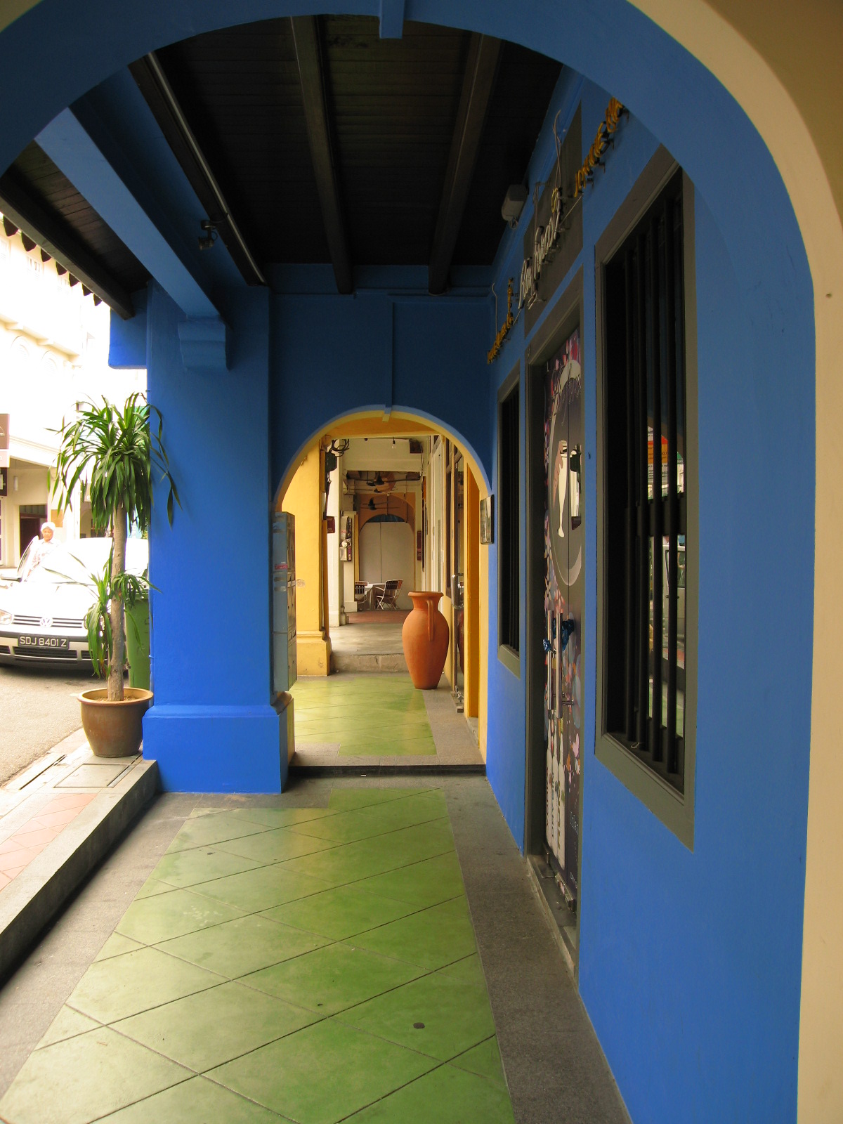 A covered five-foot way along shophouses in early morning light